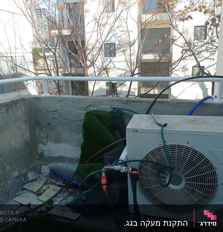 מעקה מתכת לבן על מרפסת בטון